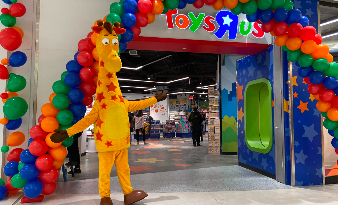 Geoffrey in front of Toys R Us store with balloon arches